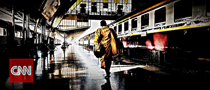 Buddhist monk walks alone inside Bangkok train station